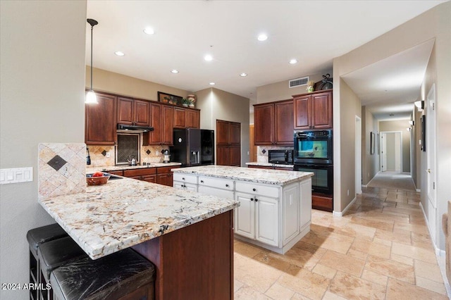 kitchen with decorative backsplash, hanging light fixtures, kitchen peninsula, black appliances, and a breakfast bar