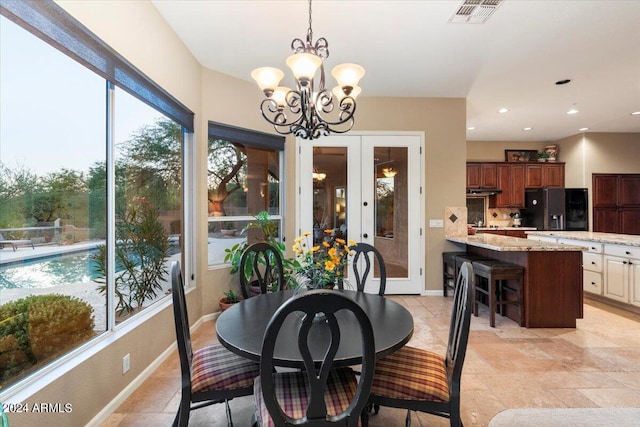 dining area with french doors and a notable chandelier