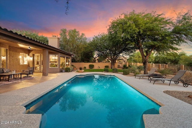 pool at dusk with a patio