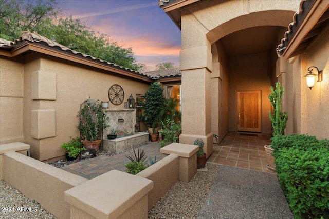 exterior entry at dusk with a patio area