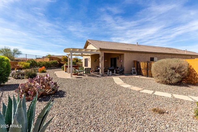 back of house with stucco siding, fence, and a patio