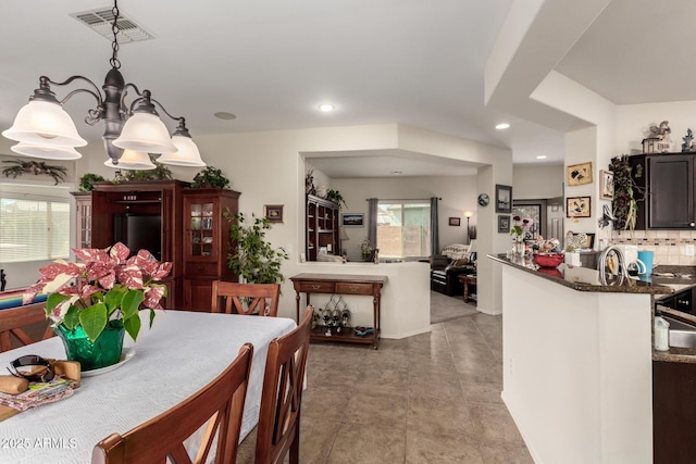 dining area with an inviting chandelier, visible vents, and recessed lighting