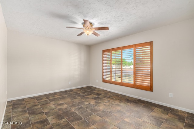 empty room with ceiling fan and a textured ceiling