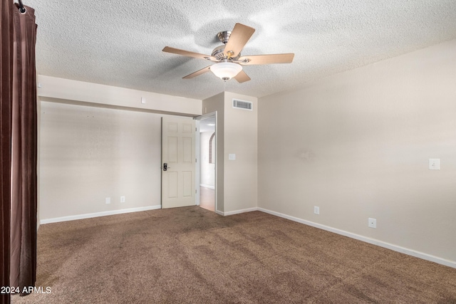 empty room with carpet flooring, ceiling fan, and a textured ceiling