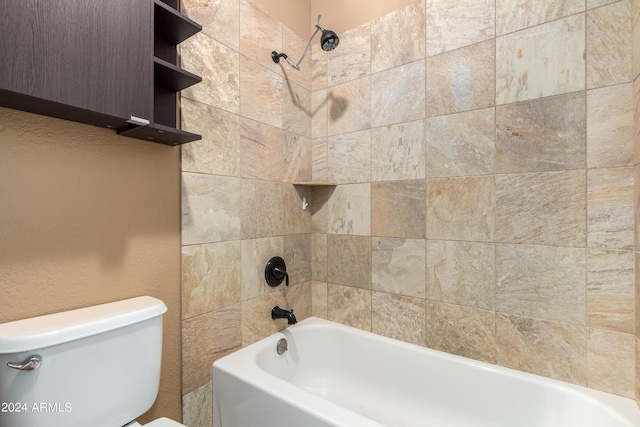 bathroom featuring tiled shower / bath combo and toilet