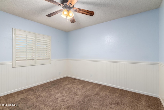 carpeted spare room with a textured ceiling and ceiling fan