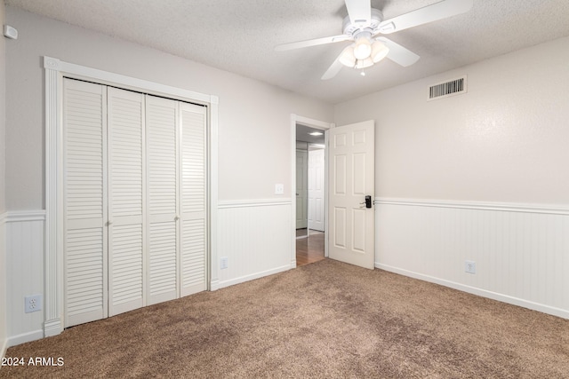 unfurnished bedroom featuring carpet flooring, ceiling fan, a closet, and a textured ceiling