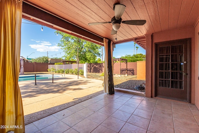 view of patio with a fenced in pool and ceiling fan