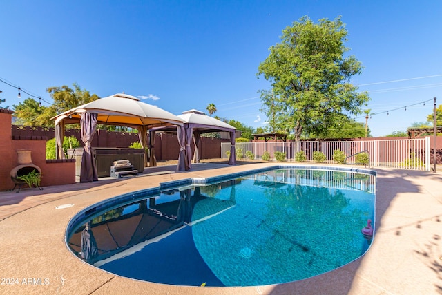 view of pool featuring a gazebo, a patio, and a hot tub