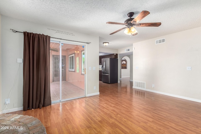 unfurnished room with ceiling fan, light hardwood / wood-style floors, and a textured ceiling