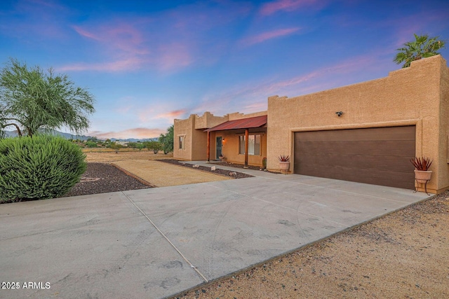 pueblo-style home featuring a garage