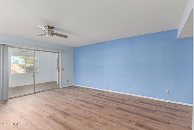 empty room with ceiling fan and light hardwood / wood-style flooring