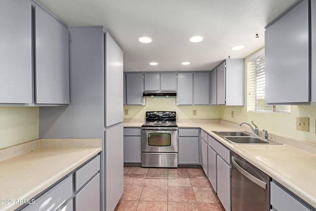 kitchen with appliances with stainless steel finishes, gray cabinetry, sink, and light tile patterned floors