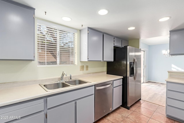 kitchen featuring a chandelier, stainless steel appliances, gray cabinets, light tile patterned flooring, and sink