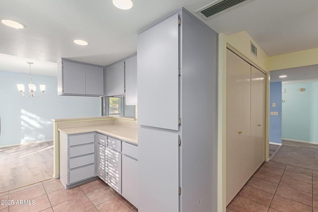 kitchen featuring decorative light fixtures, an inviting chandelier, and light tile patterned flooring