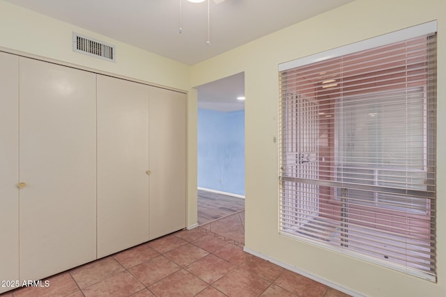 unfurnished bedroom with light tile patterned flooring and a closet