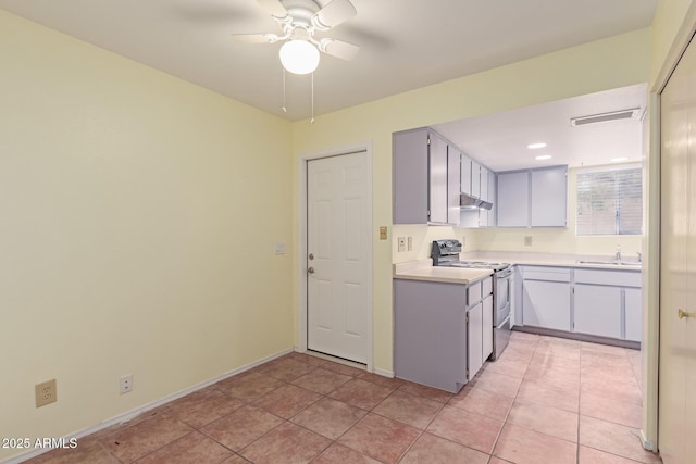 kitchen with gray cabinetry, stainless steel electric range, light tile patterned floors, ceiling fan, and sink