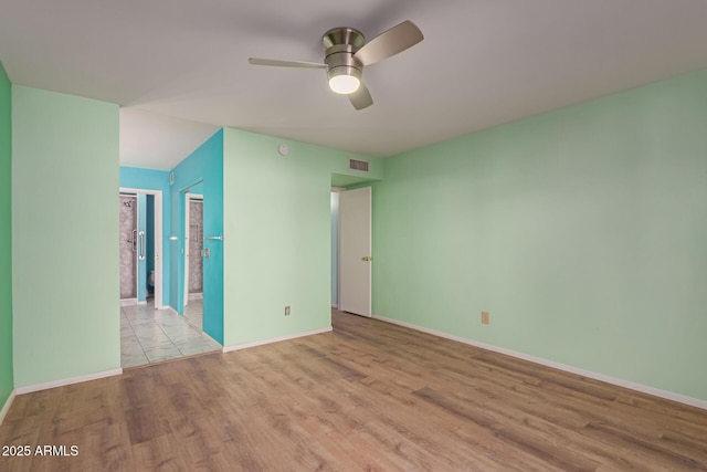 spare room featuring ceiling fan and light hardwood / wood-style floors