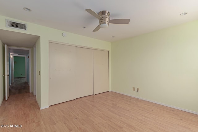 unfurnished bedroom with ceiling fan, a closet, and light hardwood / wood-style flooring