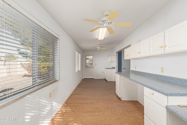 kitchen with white cabinets, ceiling fan, light hardwood / wood-style floors, and lofted ceiling