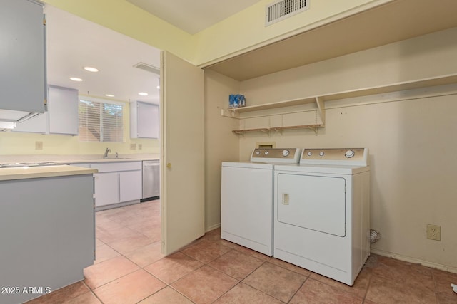 laundry area with independent washer and dryer, light tile patterned floors, and sink