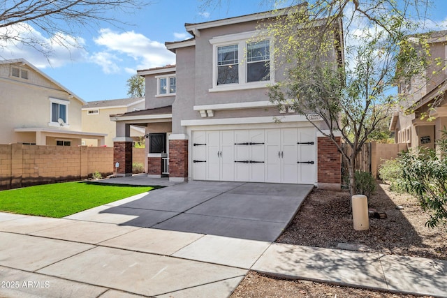 view of front of house with stucco siding, brick siding, driveway, and fence