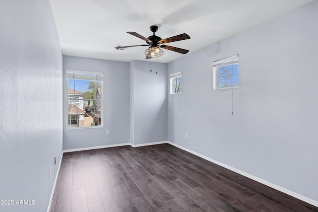 unfurnished room featuring a ceiling fan, baseboards, and dark wood-style flooring