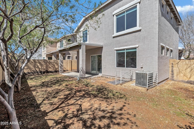 back of property featuring a fenced backyard, a patio area, stucco siding, and central AC