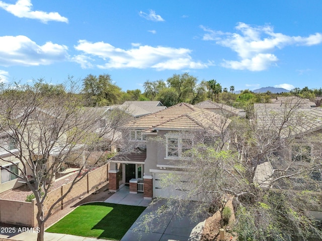 view of front of home featuring a patio, fence, an attached garage, concrete driveway, and a tile roof