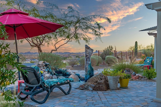 view of patio with fence and a mountain view