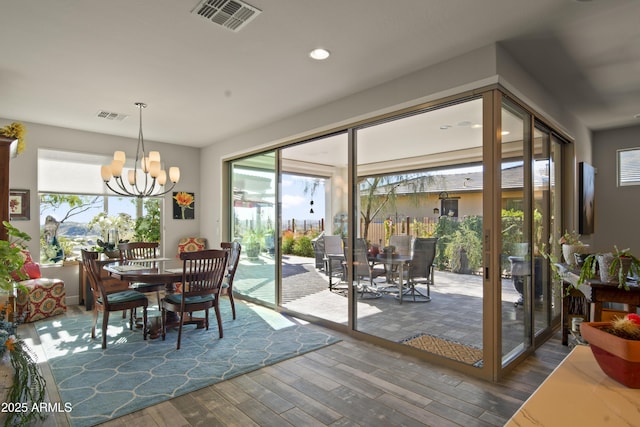 dining room featuring dark wood-type flooring, plenty of natural light, and visible vents