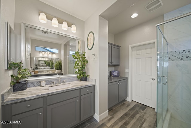 bathroom featuring recessed lighting, visible vents, a stall shower, vanity, and wood finished floors