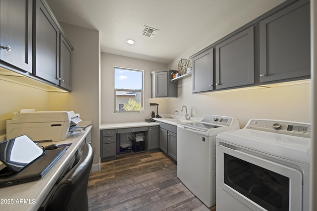 laundry room with laundry area, visible vents, dark wood-style floors, washing machine and clothes dryer, and a sink