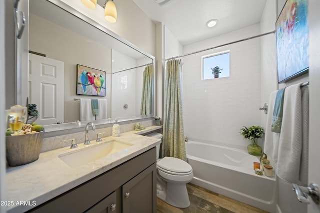 full bathroom with wood finished floors, shower / tub combo, vanity, and toilet