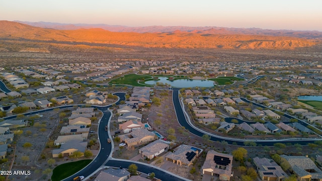 aerial view at dusk featuring a residential view and a water and mountain view