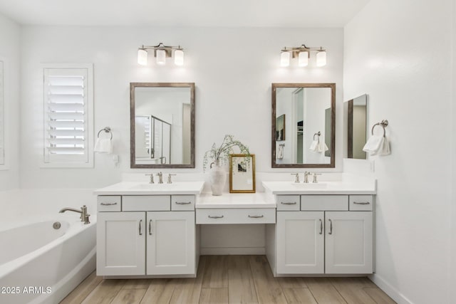 bathroom with hardwood / wood-style floors, vanity, and shower with separate bathtub