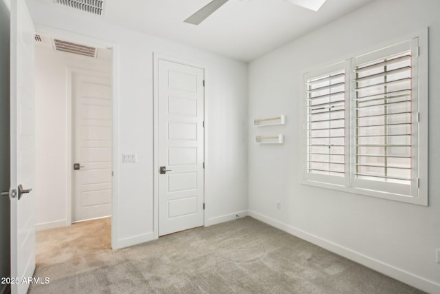 unfurnished bedroom featuring ceiling fan, multiple windows, a closet, and light carpet