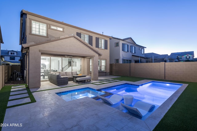 pool at dusk featuring a patio, ceiling fan, an in ground hot tub, and an outdoor living space