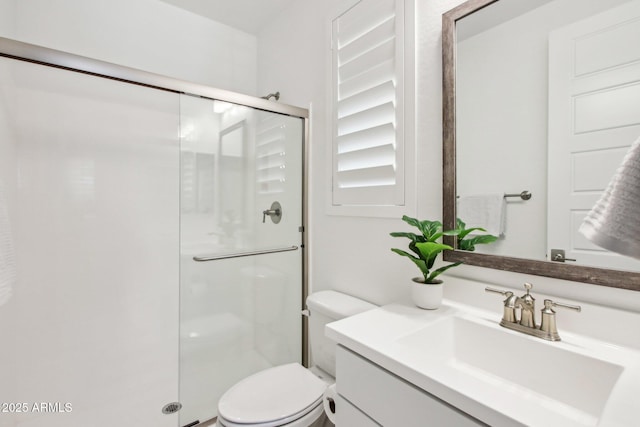 bathroom featuring vanity, a shower with shower door, and toilet