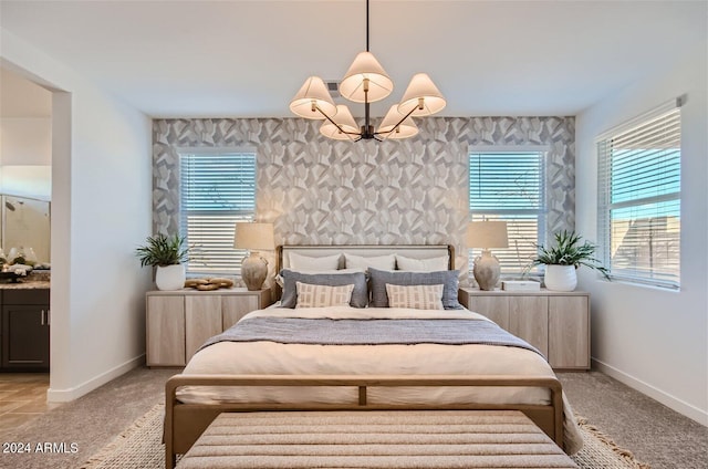 bedroom with a notable chandelier, multiple windows, and baseboards