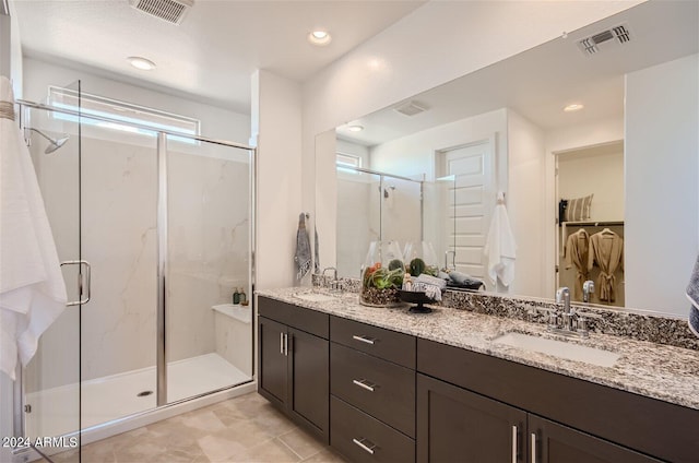 full bathroom with visible vents, a shower stall, and a sink