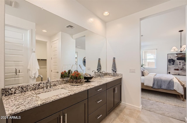 bathroom featuring double vanity, connected bathroom, visible vents, and a sink