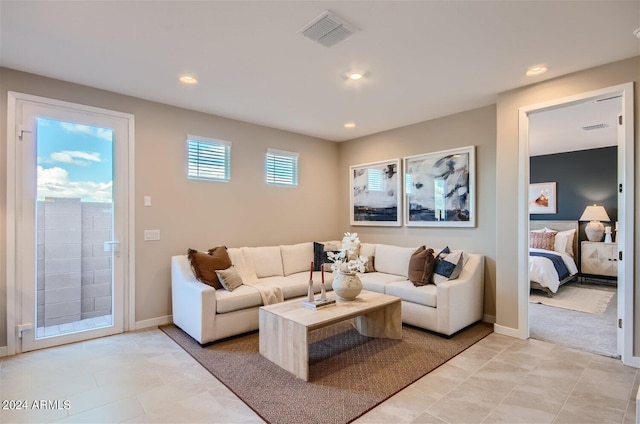 living room with light colored carpet, recessed lighting, visible vents, and baseboards