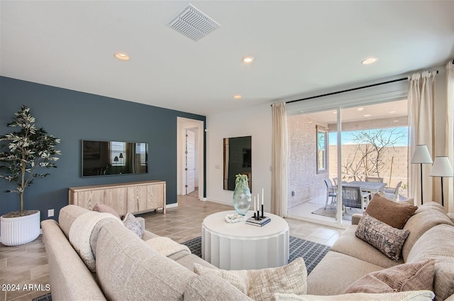 living area featuring light tile patterned floors, recessed lighting, visible vents, and baseboards