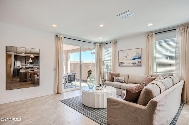 living area featuring light tile patterned floors, recessed lighting, visible vents, and baseboards