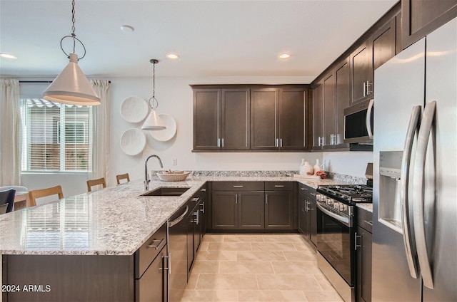 kitchen with light stone countertops, dark brown cabinetry, a peninsula, stainless steel appliances, and a sink