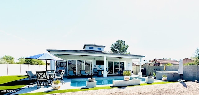 rear view of house featuring a swimming pool with hot tub and a patio area