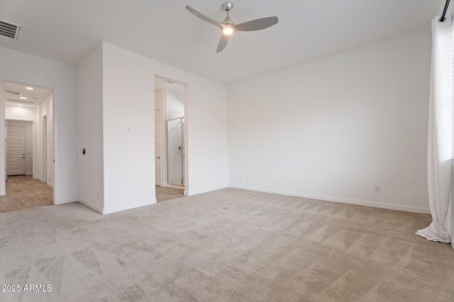 unfurnished bedroom featuring ensuite bath, ceiling fan, and light colored carpet