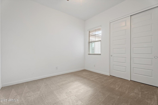 unfurnished bedroom featuring a closet and light colored carpet