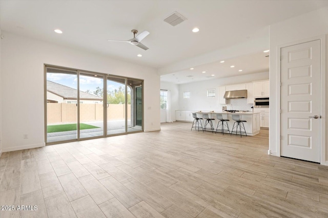 unfurnished living room featuring ceiling fan and a healthy amount of sunlight